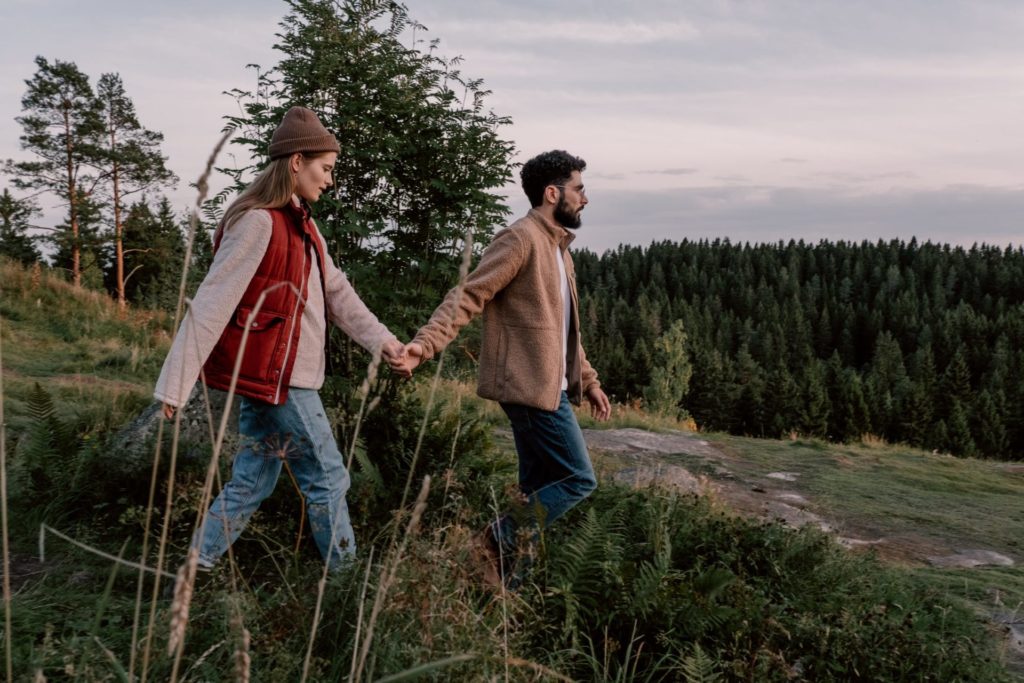 a man and woman walking in a field