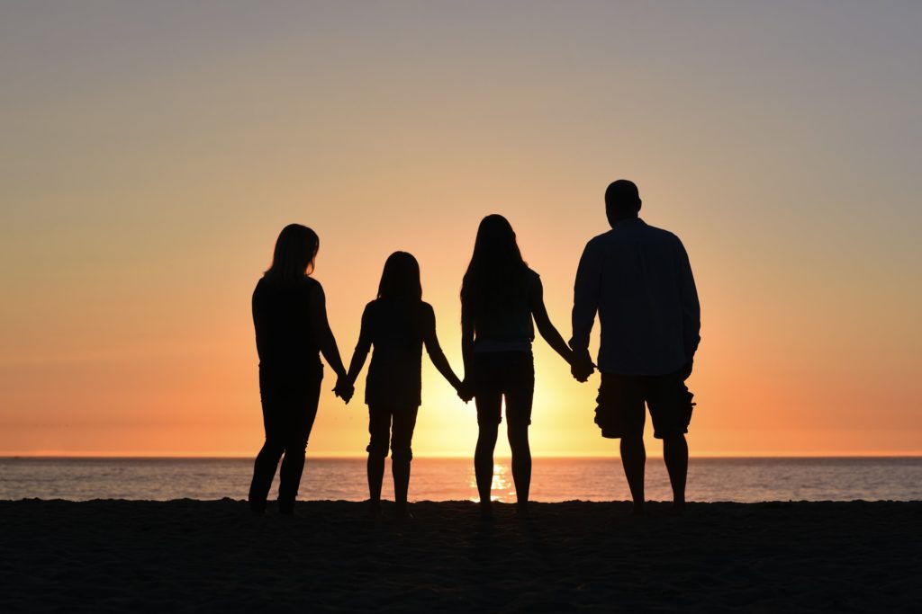 a group of people holding hands on a beach
