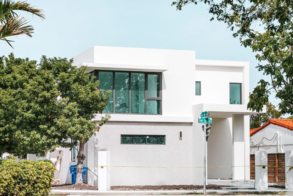 a white building with a tree in front of it