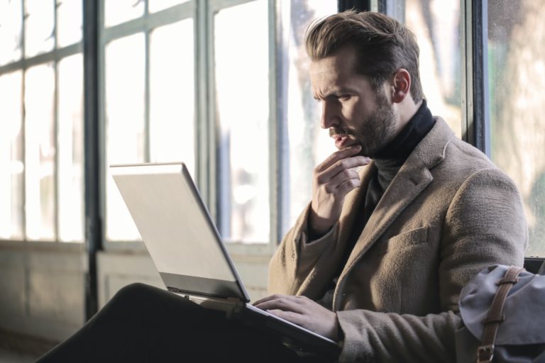 a man sitting in front of a laptop