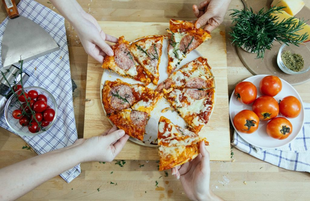 a person cutting a pizza